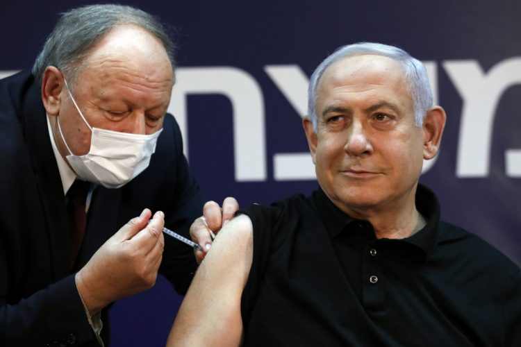 Israeli Prime Minister Benjamin Netanyahu receives a coronavirus vaccine at the Sheba Medical Center, the country's largest hospital, in Ramat Gan near the coastal city of Tel Aviv, on December 19, 2020. - Netanyahu, 71, and Israel's health minister were injected with the Pfizer-BioNTech vaccine live on TV at Sheba Medical Center. Each recipient must receive a booster shot in three weeks for optimal protection from the novel coronavirus. (Photo by AMIR COHEN / POOL / AFP)