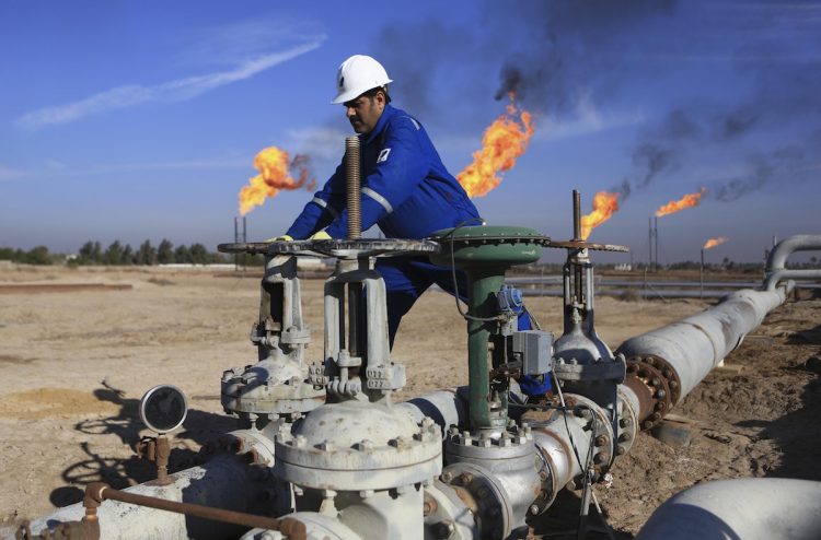 An Iraqi worker operates valves in Nihran Bin Omar field north of Basra, 340 miles (550 kilometers) southeast of Baghdad, Iraq, on January 12, 2017. Photo: AP/File