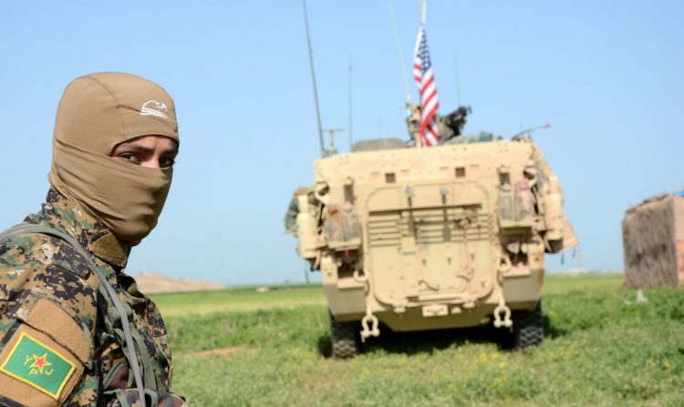 2017-04-29 00:00:00 epa05935402 A Soldier of the People's Protection Units (YPG) Kurdish militia stands next to a US eight-wheeled armored fighting vehicles, near al-Ghanamya village, al-Darbasiyah town at the Syrian-Turkish border, Syria, 29 April 2017. The Turkish army allegedly shelled several locations belonging to the YPG a day earlier with no casualties.  EPA/YOUSSEF RABIE YOUSSEF